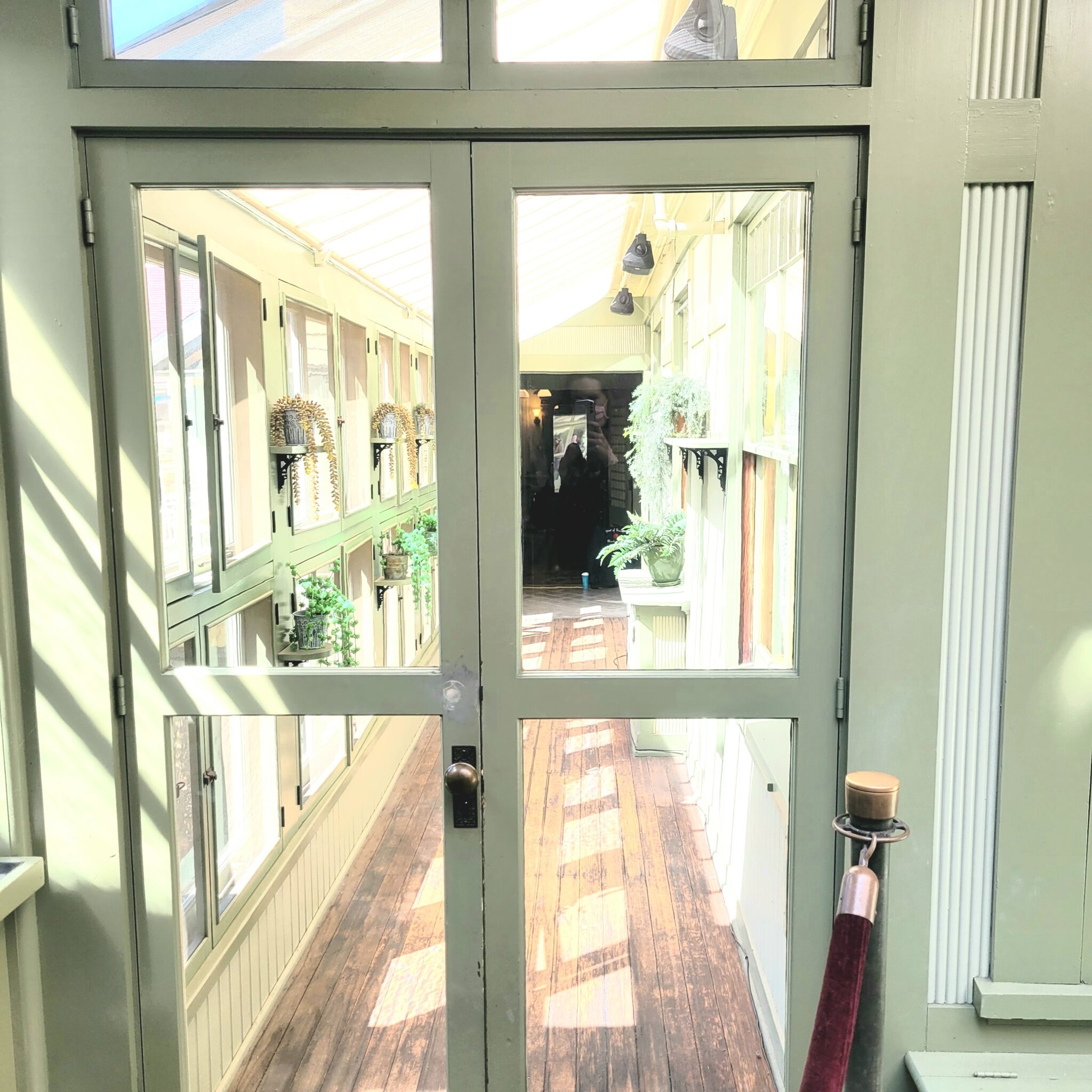 This photo was shared by Cheyenne A. from Nebraska, who visited in the spring of 2021. Later that evening, while reviewing her photos, she noticed a figure at the end of a hallway. She pointed out that her friend took a photo of the same hallway at the same time with nothing there. Her and her friend’s reflections can be seen in the mirror behind the figure.