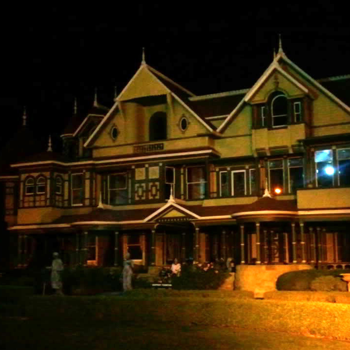 This photo was shared by Kaehla L. from California, taken during the flashlight tours in October 2010. She noted that the front of the house was roped off and no one else was around, yet she later noticed what looks to her like the figure of an older woman standing on the front steps in a white shirt.